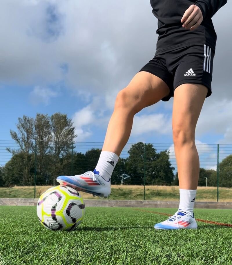 Emily playing football in adidas F50 football boots